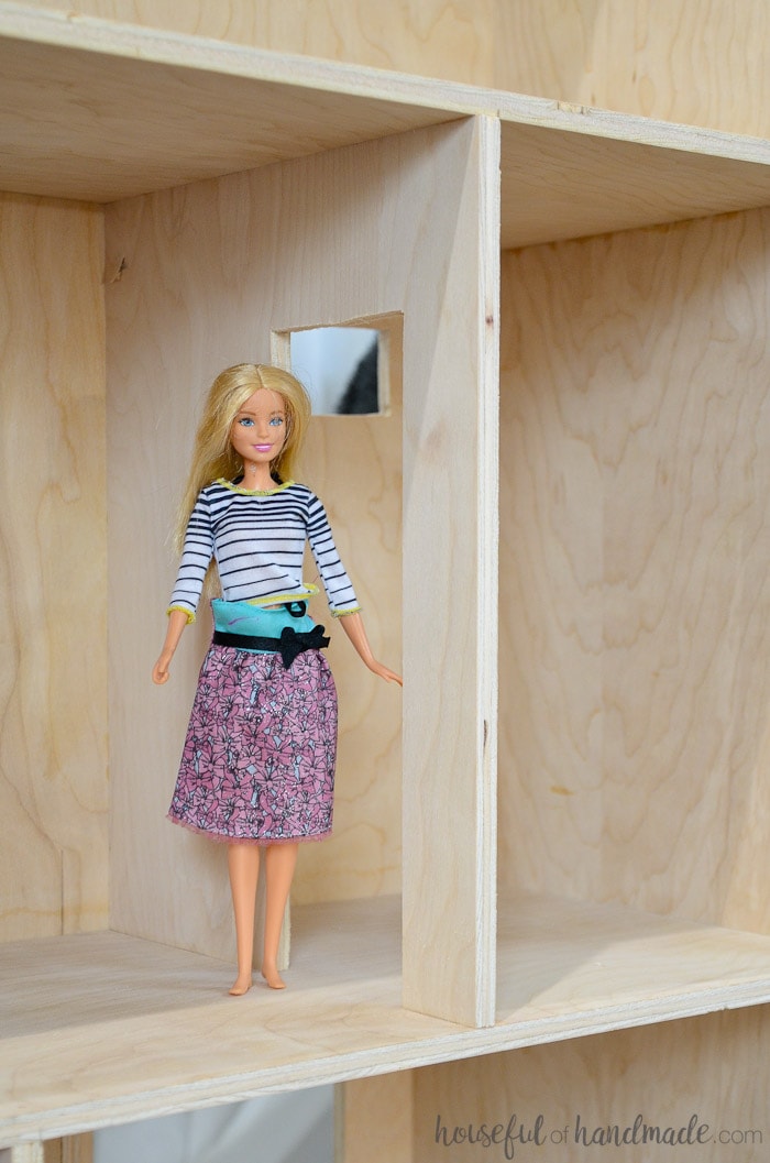 Beautiful handmade dollhouse shown with barbie on shelf